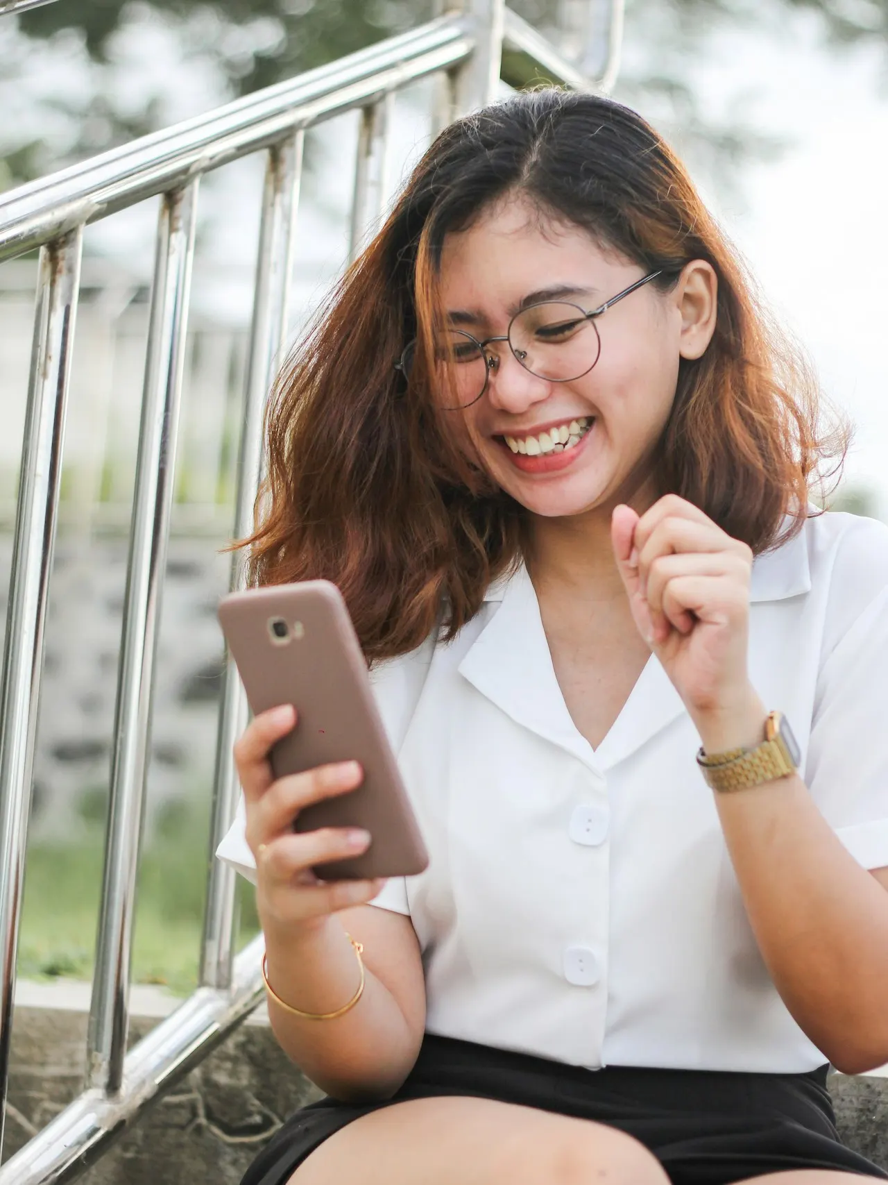 Creator in glasses laughing with a phone in hand