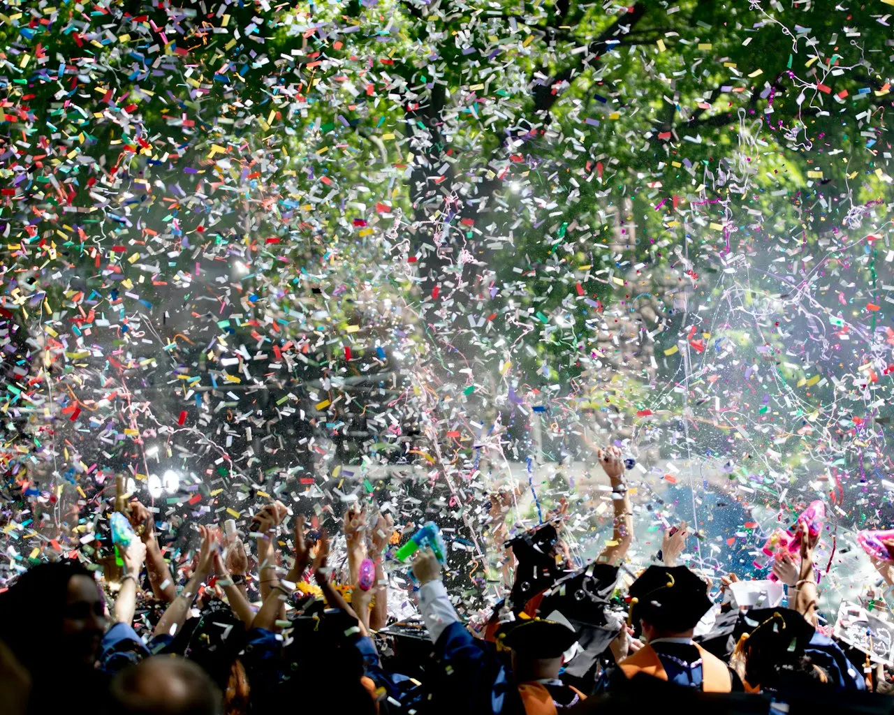 A crowd celebrating under falling confetti