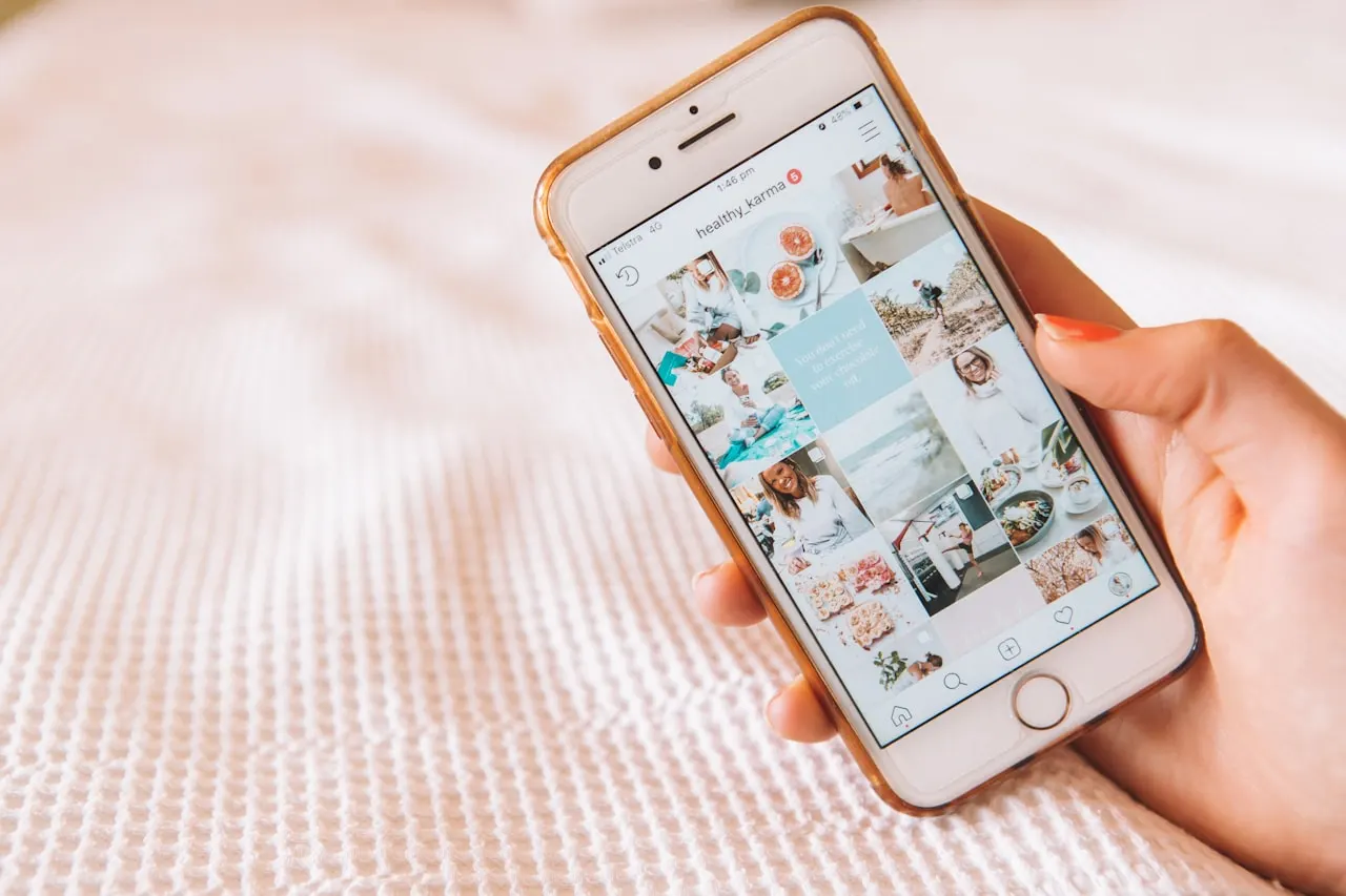 Hand holding a phone showing a social media feed